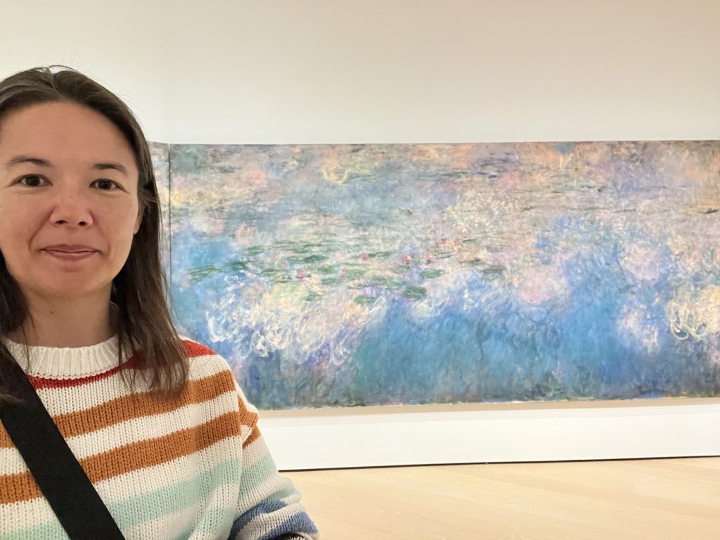 Sarah in front of a Monet painting of water lilies at the Museum of Modern Art in New York City